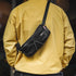 Person wearing a yellow jacket with a black waist bag on a blurred background